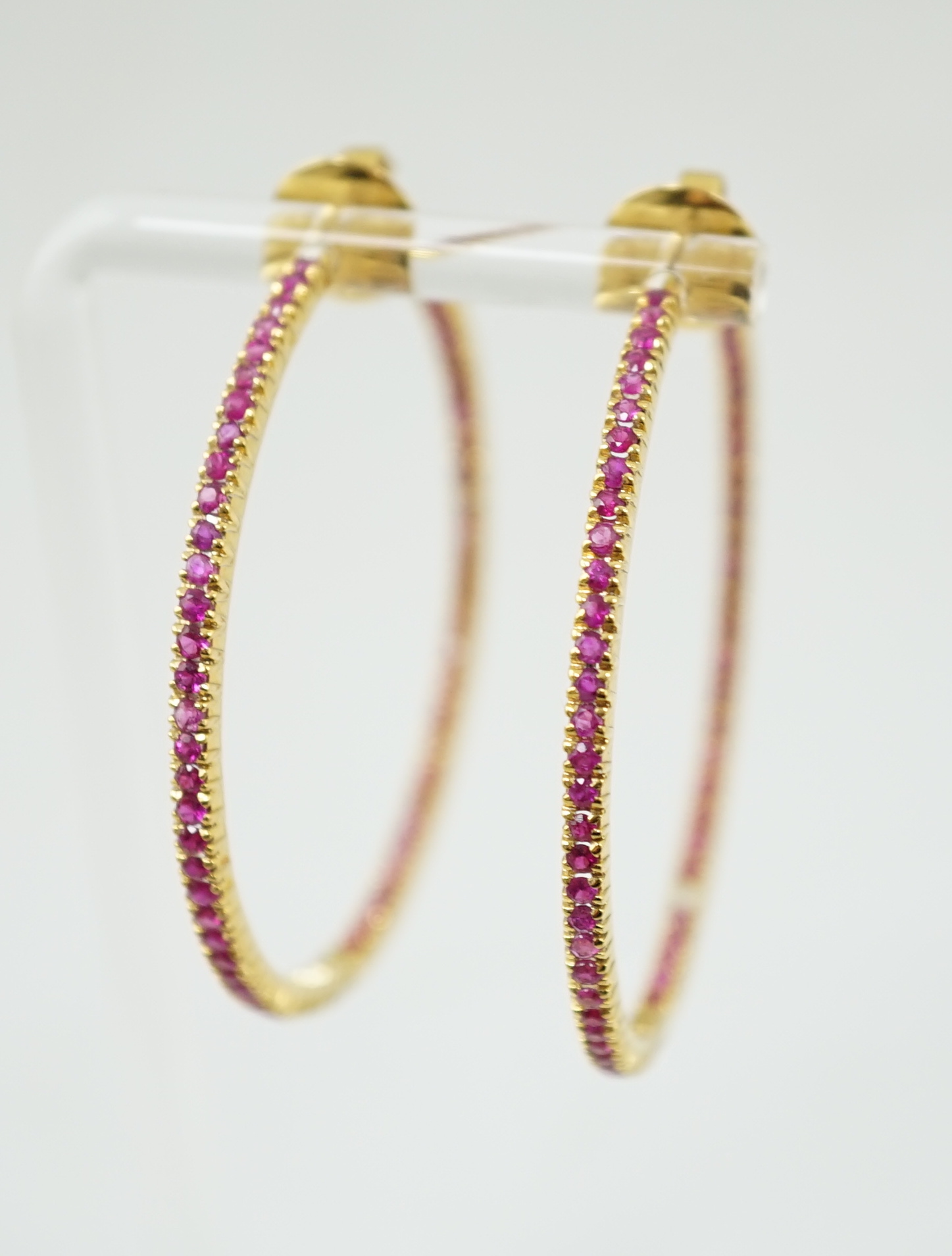 A large pair of gold and ruby chip set hoop earrings